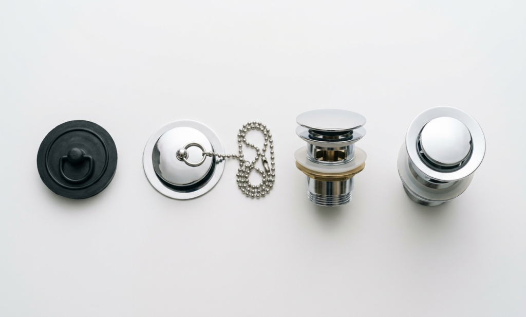 Bathroom Plug Guide: How to Choose, Fit, and Fix the Right One Four different types of bathroom plugs laid out side by side: rubber suction, chain, pop-up, and click-clack
