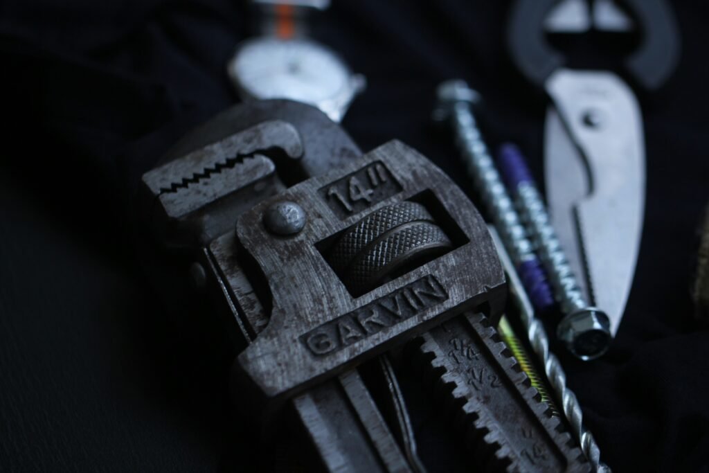 A close-up of a pipe wrench gripping a metal pipe