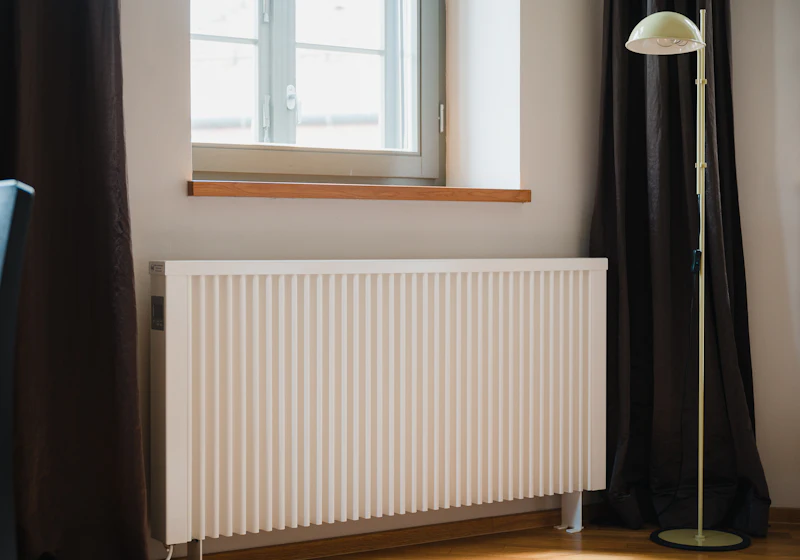 White central heating radiator beneath a window – boiler and heating services in London