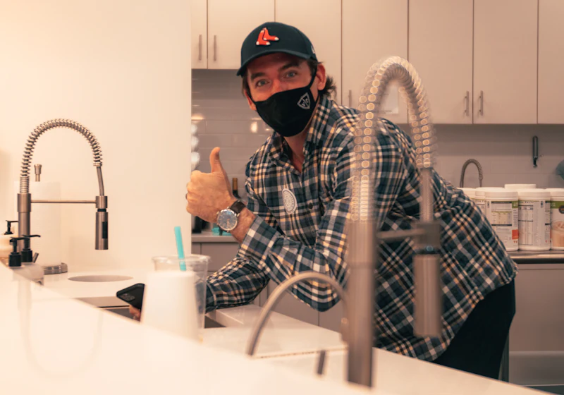 Plumber at a newly fitted kitchen mixer tap – residential and commercial plumbing in London